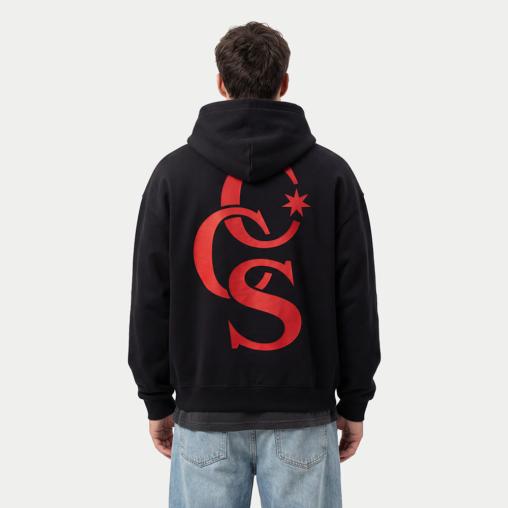 Model seen from behind wearing the CCS Monogram red hoodie by Caracas Merch